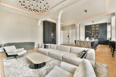 Zarif mobilyaların, şık dekorun ve bol doğal ışığın bulunduğu güzel tasarlanmış modern bir oturma odası sıcak ve davetkar bir atmosfer yaratıyor..