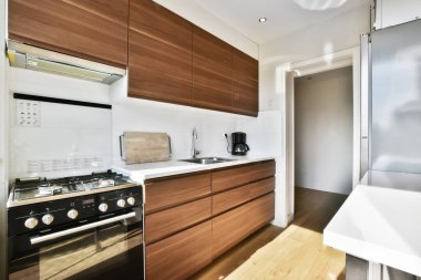 Yeni lüks bir evde mutfak, ahşap döşemeler, karanlık dolaplar.