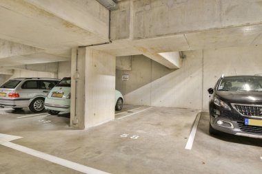 Temiz, aydınlık, modern bir yeraltı otoparkı farklı park araçları sergiliyor, kentsel park ihtiyaçları için organize bir alan çiziyor..