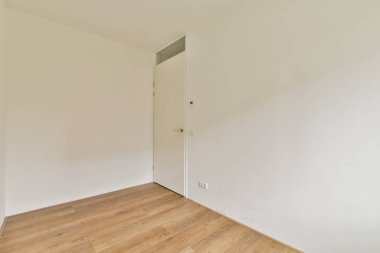 Beyaz duvarları ve ahşap zemini olan geniş bir iç mekan. Modern yaşam alanları için minimalist bir estetik..