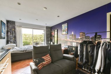 Şık bir yaşam alanı büyüleyici bir şehir manzarası, modern mobilyalar ve parlak bir pencere içeriyor. Hoş bir atmosfer yaratıyor..