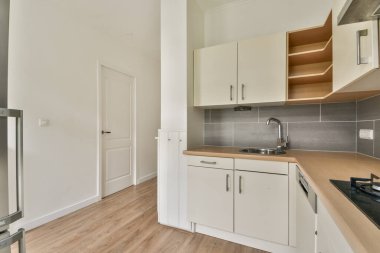 Zarif bir şekilde tasarlanmış modern bir mutfak. Gösterişli kabinler, paslanmaz çelik aletler ve işlevselliği ve stili arttıran minimalist bir estetik..