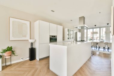 Parlak ışıklandırma, modern aletler ve yemek pişirme ve yemek pişirme için fonksiyonel bir tasarımı olan gösterişli ve çağdaş bir mutfak..