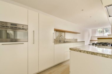 Çağdaş bir mutfak, gösterişli kabinler, zarif tezgahlar, ve iyi organize edilmiş bir düzen, aşçılık ve toplanma için mükemmel..