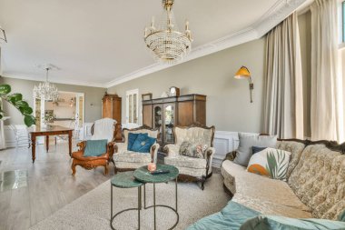 Zarif mobilyalar, dekoratif ışıklandırma ve sıcak ve davetkar bir atmosfer yaratan ahenkli bir renk paleti olan modern bir oturma odası..