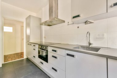 Gösterişli beyaz dolap ve minimalist bir düzen, çağdaş bir his için açık bir alan ve yüksek kaliteli cihazlara sahip bu modern mutfağı tanımlar..