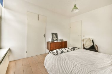 Sakin ve minimalist bir yatak odası. Basit bir yatak odası, zarif bir dekor ve pencerelerden süzülen doğal bir ışık..