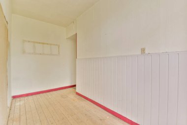 Parlak ve havadar bir iç döşeme ve beyaz duvarlar, canlı kırmızı bir dokunuşla tamamlanmış minimalist bir estetik yaratıyor..