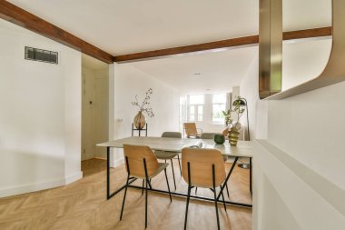 Ahşap aksanlı ve basit mobilya yerleşimi olan minimalist bir dizaynın yer aldığı geniş, iyi ışıklandırılmış bir oda. Doğal ışık, sakin atmosferini arttırır..