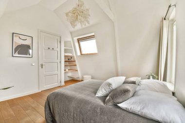 Tarafsız tonlara, geniş pencerelere ve rahatlatıcı bir atmosfer yaratan minimalist dekor elementlerine sahip geniş bir iç mekan..