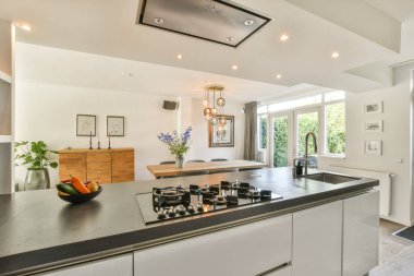 Minimalist tasarım elementleri, doğal ışık ve işlevselliği ve estetiği geliştiren şık dekorasyonlu gösterişli modern bir mutfak..