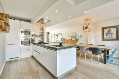 Modern bir mutfak, şık dolaplar, zarif eşyalar, ve davetkar bir yemek alanı, aile yemekleri ve toplantılar için mükemmel..