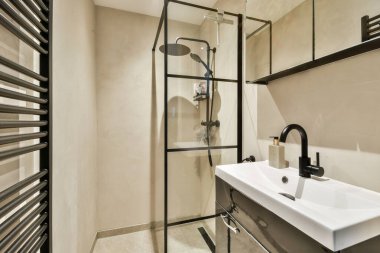 Gösterişli ve çağdaş banyo, cam duş muhafazası, modern lavabo ve şık eşyalar, işlevselliği zarafetle birleştirmek..