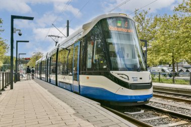 Şık, modern bir tramvay yeşilliklerle çevrili bir şehir istasyonunda bekliyor. Şehir ortamında toplu taşıma ve doğa entegrasyonunu gözler önüne seriyor..