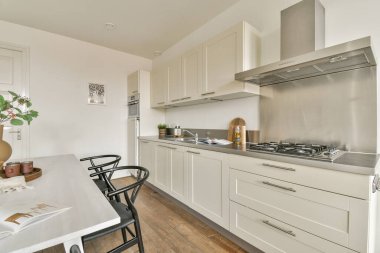 Gösterişli, modern bir mutfak, minimalist dolaplar, paslanmaz çelik aletler, ve ahşap zemin. Parlak ve havadar tasarım çağdaş yaşam için mükemmel..