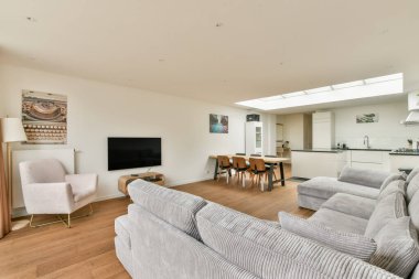 Konforlu bir oturma odası, açık mutfak tasarımı ve davetkar bir atmosfer için çağdaş dekorasyon..