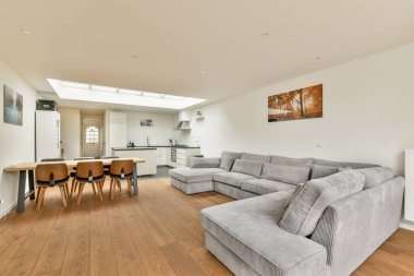 Modern mobilyaların sergilendiği şık bir oturma odası, geniş doğal ışık ve minimalist dekor, rahatlamak için mükemmel bir ortam yaratıyor..