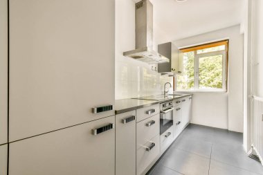 Parlak ve çağdaş bir mutfak. Minimalist dolaplar, modern aletler ve camdan içeri yayılan bol miktarda doğal ışık..