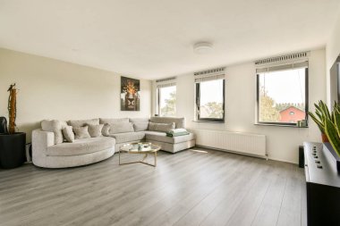 Geniş bir kanepe, geniş pencereler ve zarif bir dekorun bulunduğu çağdaş bir oturma odası, rahatlama ve sosyal etkinlikler için mükemmel..