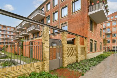 Çağdaş bir apartmanda, sürdürülebilir bir çevrede kentsel yaşamı destekleyen, balkonları ve entegre yeşil alanları olan şık bir mimari yer alıyor..