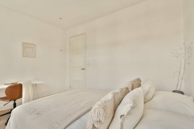 Hafif bir palet, yumuşak dokular ve modern mobilyalar içeren sakin ve minimalist bir yatak odası. Huzurlu ve davetkar bir atmosfer yaratıyor..