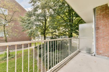 Sergilenen sakin bir balkon, yemyeşil ağaçlar ve iyi korunan bir çevre. Rahatlamak ve doğanın tadını çıkarmak için mükemmel..