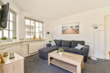 Rahat bir kanepe, doğal ışık, minimalist dekor ve rahat bir ortam, rahatlama ve sosyal etkinlikler için ideal bir oturma odası..