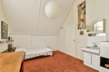 Parlak ve davetkar yatak odası yumuşak halılar, basit bir yatak ve zarif dekorasyon unsurları. Mükemmel bir konfor ve stil karışımı alanı geliştirir..