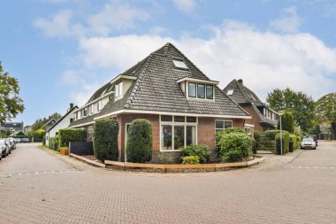 Benzersiz bir mimari tasarımı olan pitoresk bir ev yemyeşil yollar ve huzurlu bir mahalle ile çevrilidir..