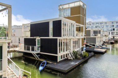 Zarif yüzen evler, sakin suyla çevrili çağdaş mimari sergiliyor. Rıhtımda yaşam ve yenilikçi tasarımlar için ideal..