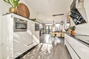 Parlak modern mutfak gösterişli aletler, çağdaş tasarım ve geniş pencerelerden akan geniş doğal ışık geniş bir atmosfer yaratıyor..