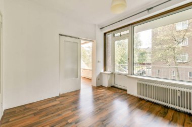 Geniş iç mekan, geniş pencereler arasından doğal ışık, zarif ahşap döşeme ve modern yaşam için mükemmel minimalist tasarım..