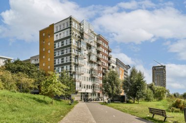 Çağdaş bir konut yapısı yemyeşil ve yol ile pürüzsüz bir şekilde bütünleşerek sakin bir kentsel geri çekilme sunar..