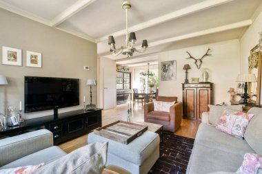 Güzel tasarlanmış modern bir oturma odası şık bir kanepe, zevkli bir dekor ve sıcak bir ışıklandırma, rahatlama ve sosyal toplantılar için mükemmel..