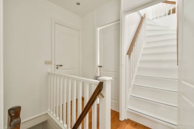 Modern bir merdiven sergilenen parlak ve temiz bir iç mekan. Tasarım, basitlik ve zarafeti, doğal ışığa odaklanarak vurgular..