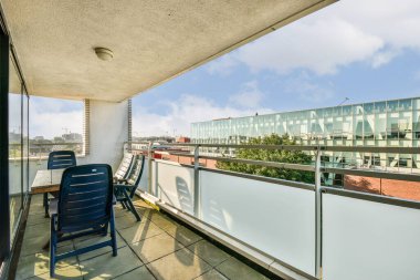 Şık, modern bir balkon. Oturma ve geniş bir şehir manzarası manzarası. Rahatlamak için sakin bir açık hava alanı sağlıyor..