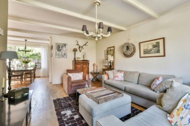 Güzel tasarlanmış oturma odası rahat bir kanepe, şık bir dekor ve doğal ışığı ve sıcaklığı karşılayan bir yemek salonu..