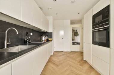 Gösterişli ve modern bir mutfak, minimalist dolaplar, temiz çizgiler, ve sakinleştirici bir renk paleti, çağdaş yaşam alanları için ideal..