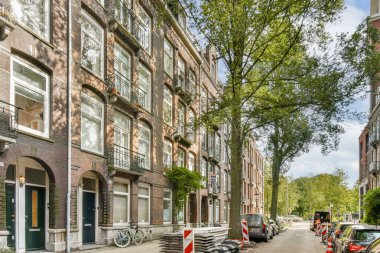 Yeşillik ve bisikletlerle süslenmiş ve şehir hayatının özünü yansıtan tarihi bir mimariyi sergileyen tuhaf bir şehir caddesi..