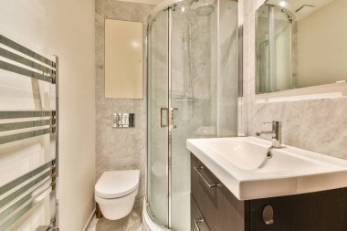 Parlak, çağdaş bir banyo, cam duş muhafazası, şık bir lavabo ve ferahlatıcı bir ortam için zarif bir çalışma..