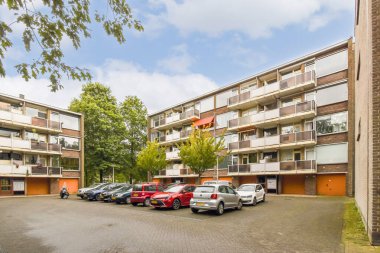 Birden fazla kat, balkon ve sakinler için açık park alanı olan çağdaş bir apartman. Çevreleyen yeşillik cazibesini artırır.