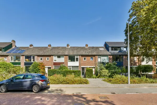 Modern evlerin, yemyeşil bahçelerin ve iyi korunmuş kaldırımların bulunduğu rahat bir mahalle manzarası. Huzurlu bir yaşam için ideal..