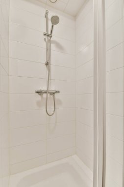 Parlak bir banyoda modern duş kabini.