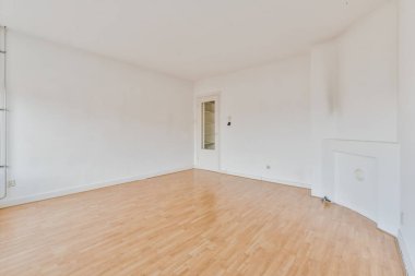 Klasik boş oda. Ahşap zemin, beyaz duvarlar ve beyaz bir kapı.