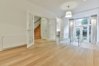 Beyaz ahşap kapılı, parlak, boş bir salonun içinde.