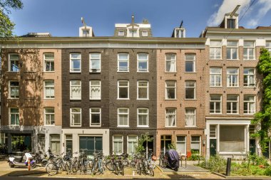 Caddenin kenarına park etmiş bir apartmanın önünde bir sürü pencere ve bant var.