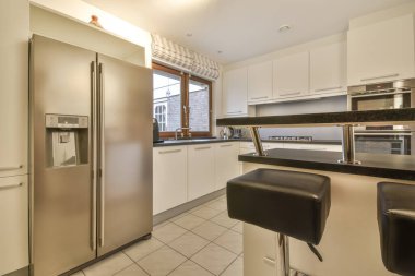 Yeni lüks bir evde mutfak, ahşap döşemeler, karanlık dolaplar.