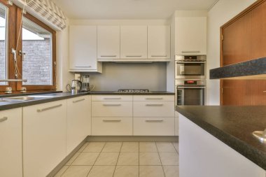 Yeni lüks bir evde mutfak, ahşap döşemeler, karanlık dolaplar.