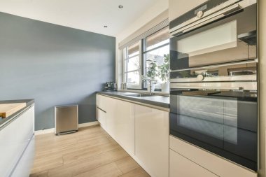 Yeni lüks bir evde mutfak, ahşap döşemeler, karanlık dolaplar.