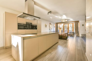 Yeni lüks bir evde mutfak, ahşap döşemeler, karanlık dolaplar.